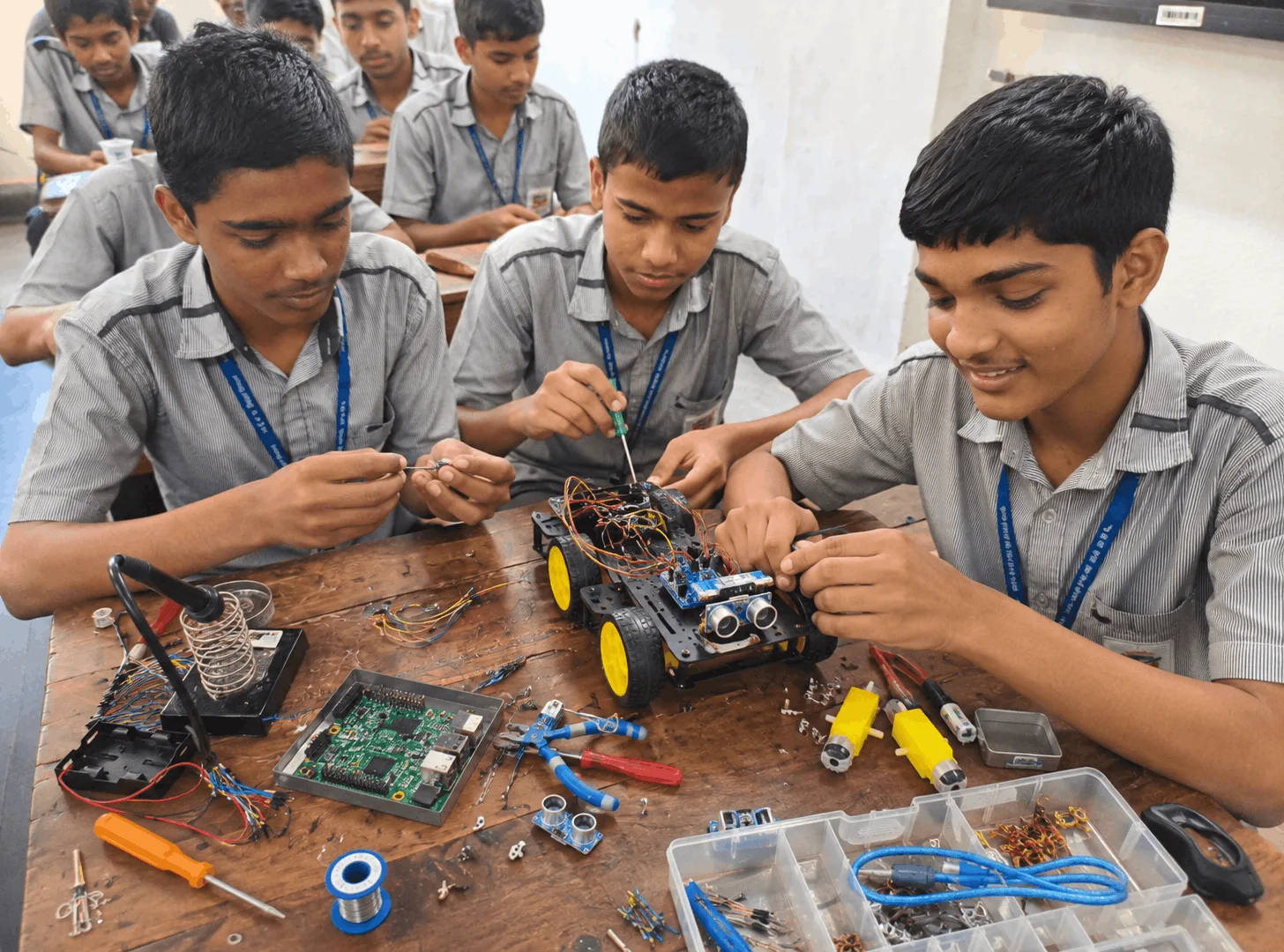 School students assembling and programming a robotics kit in an AI and robotics lab